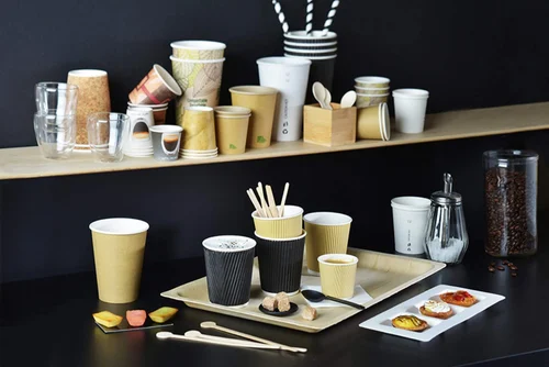 Mescolatori per caffè in bambù con tazze e snack su un tavolino da ufficio Mescolatori per caffè in bambù con tazze e snack su un tavolino da ufficio