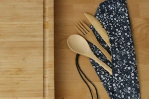Bamboo utensils with cloth napkin on a wooden surface