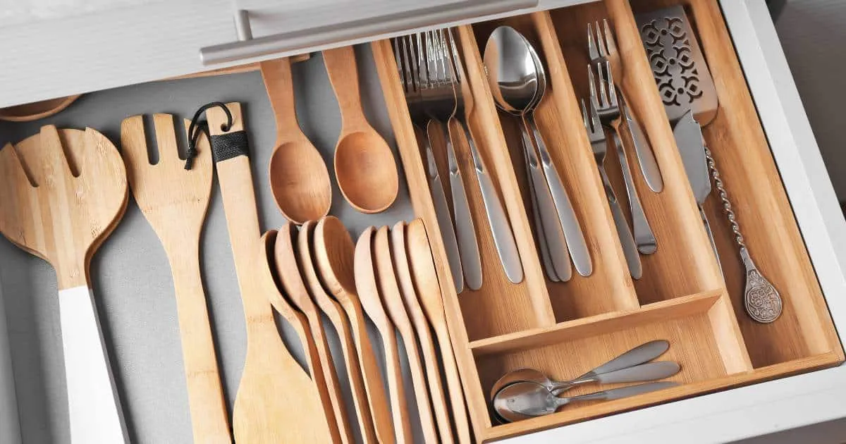 Cassetto della cucina organizzato con utensili in teak e bambù Cassetto della cucina organizzato con utensili in teak e bambù