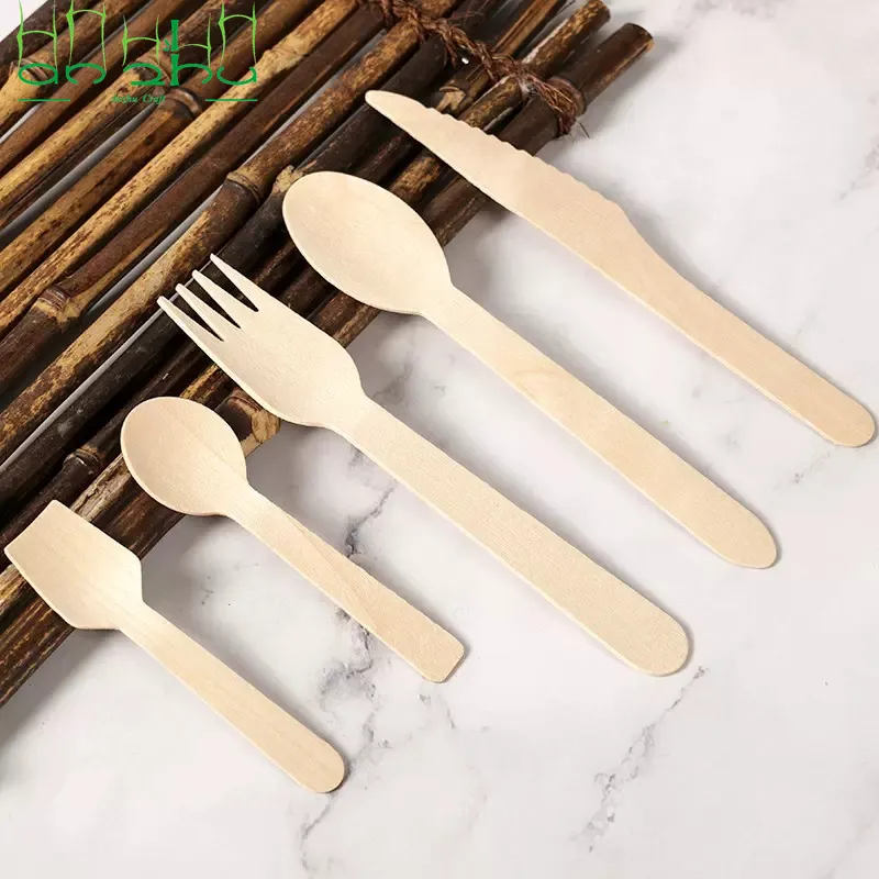 Conjunto de talheres descartáveis de madeira sobre tapete de mármore e bambu