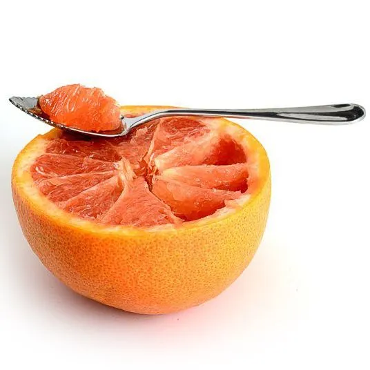 Grapefruit spoon scooping juicy pink fruit Grapefruit spoon scooping juicy pink fruit