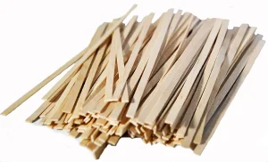 Pile of flat wooden coffee stir sticks on white background