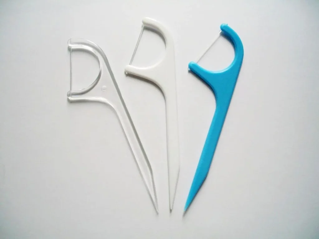 Three plastic floss picks in clear white and blue colors