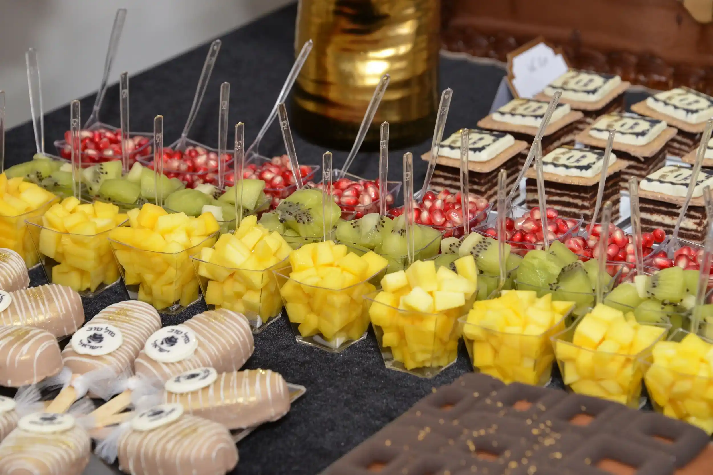 Frutas variadas servidas con cucharas de plástico transparente a juego.