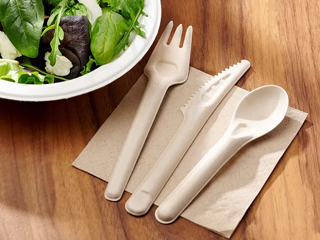 Juego de cubiertos ecológicos y duraderos junto a una ensalada fresca.