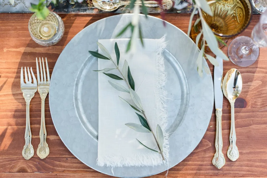 Elegante arranjo de mesa com talheres de prata e prato de serviço Elegante arranjo de mesa com talheres de prata e prato de serviço