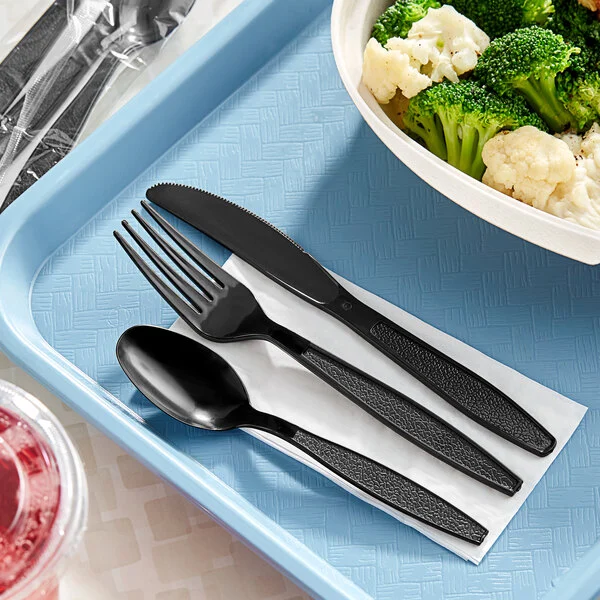 Cubiertos desechables de plástico negro extra pesados sobre la mesa