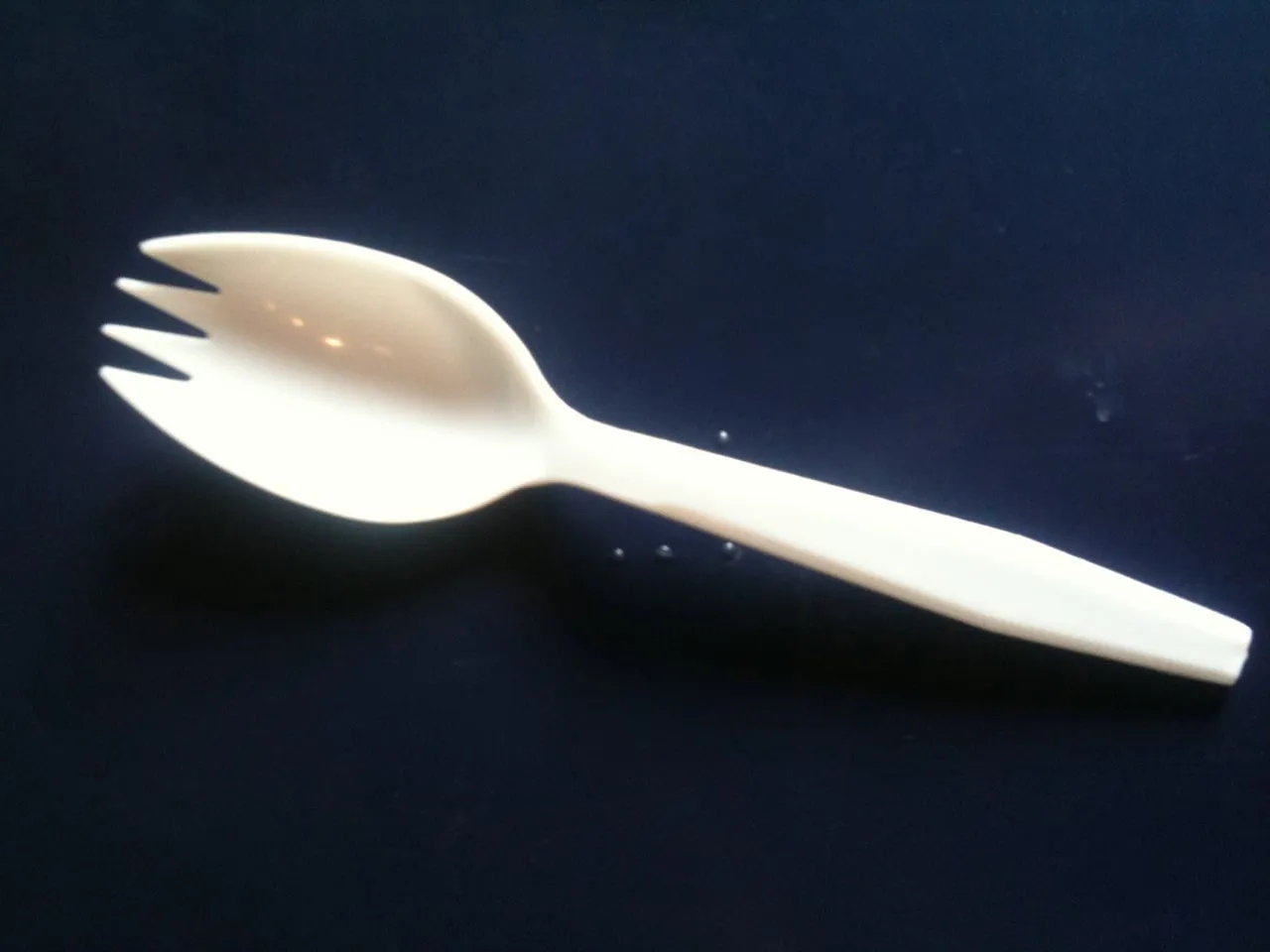 Weißer Plastik-Göffel auf schwarzem Untergrund
