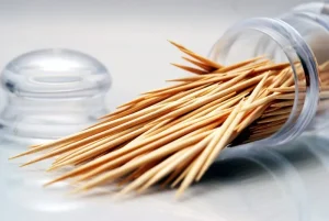 Close up of wooden toothpicks spilling from plastic case