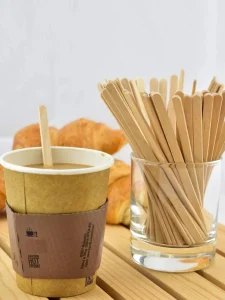 Hot coffee cup with wooden stirrers in glass jar