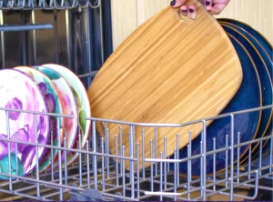 Open dishwasher filled with plates and utensils