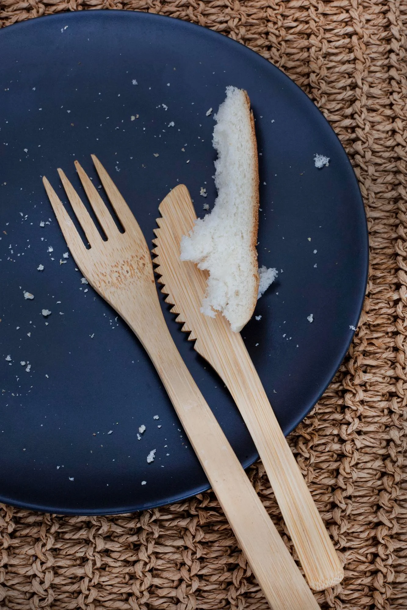 Used bamboo fork and knife on plate with crumbs Used bamboo fork and knife on plate with crumbs