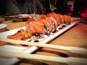 Close up of sushi roll with salmon and sauce drizzle