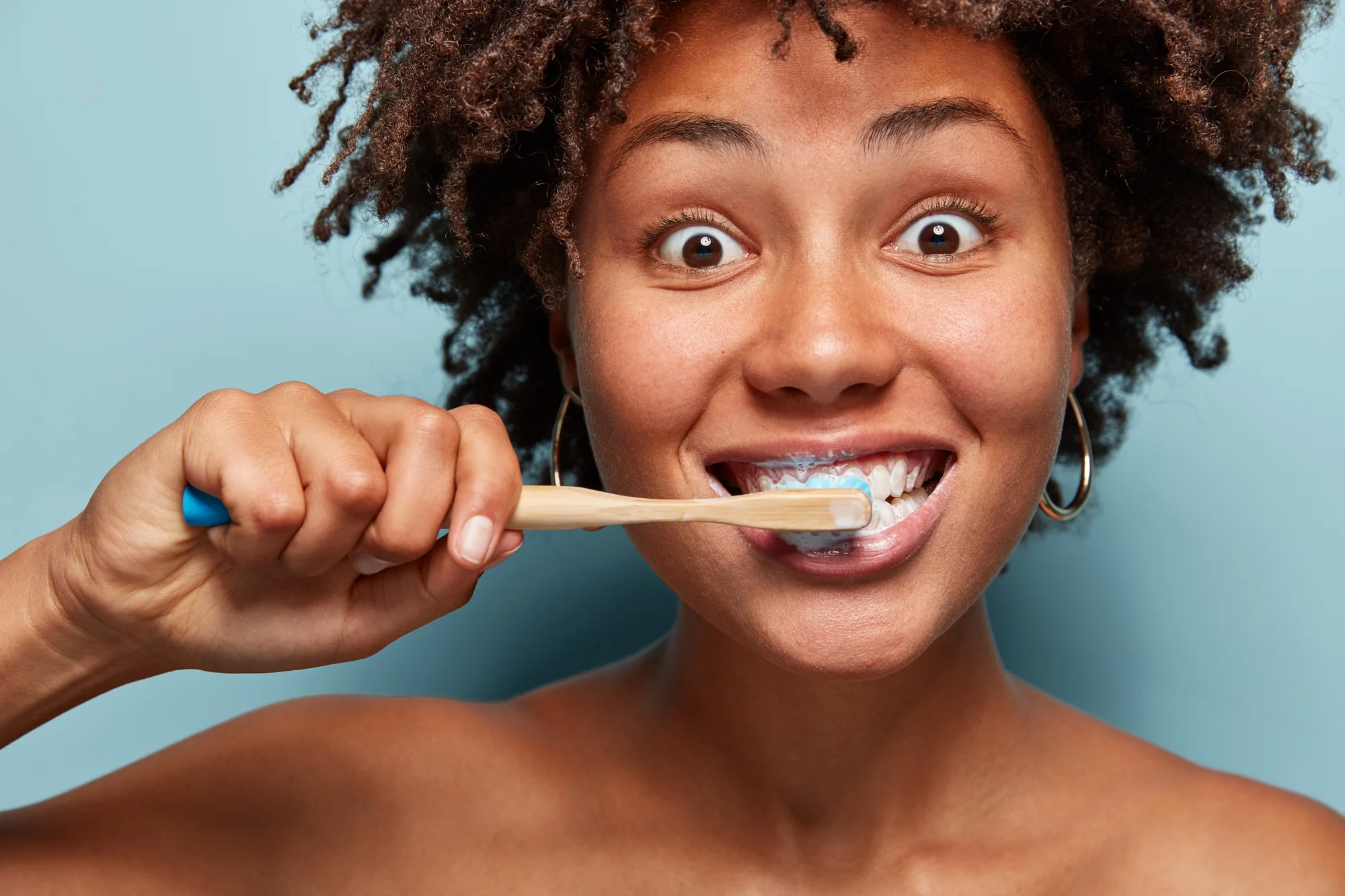 Happy woman brushing teeth with bamboo toothbrush Happy woman brushing teeth with bamboo toothbrush