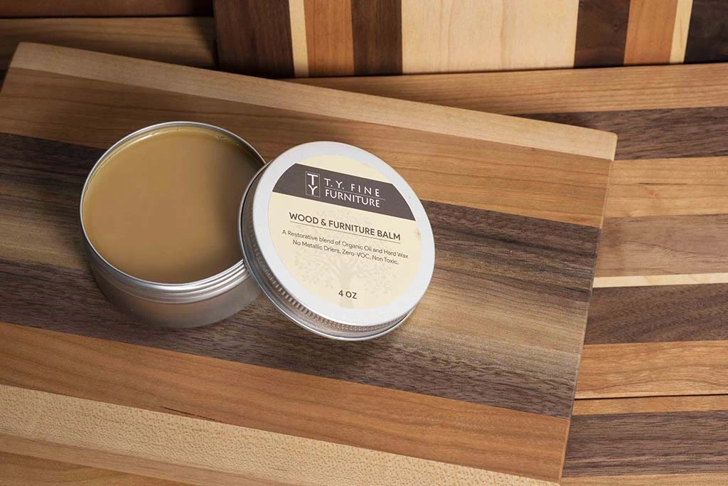 Wood balm tin on assorted wooden cutting boards Wood balm tin on assorted wooden cutting boards